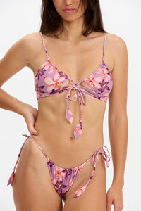 Woman wearing a pink floral bikini against a white background